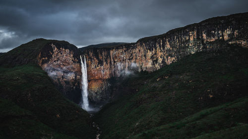 Scenic view of waterfall against sky