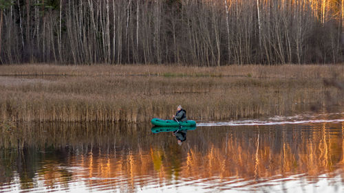 Man in boat on lake in forest