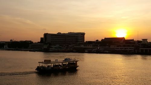 Boats in sea at sunset