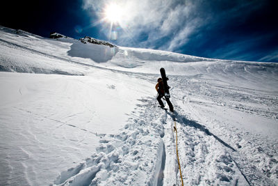 Man skiing on snowcapped mountain against sky