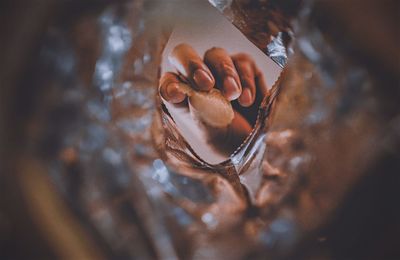 Hand hold potato chip inside snack bag