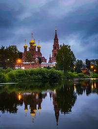 Reflection of building in lake against sky