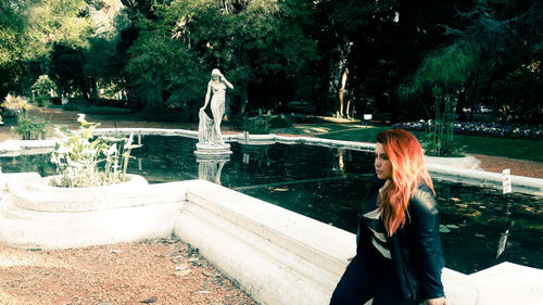 Woman standing by trees in park