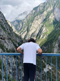 Rear view of man standing on footbridge