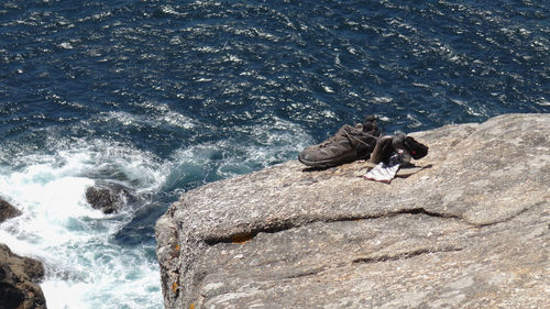 High angle view of people on rock in sea