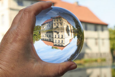 Close-up of hand holding crystal ball with reflection