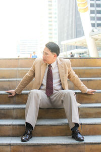 Mature businessman sitting on steps