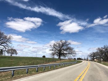 Road by field against sky