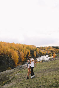 Happy people in love are travel hike in nature in the autumn forest. romantic trip to countryside