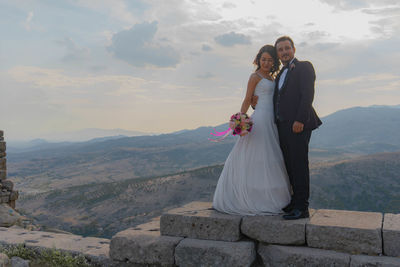 Rear view of couple kissing against mountain