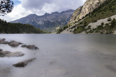 Scenic view of lake by mountains against sky