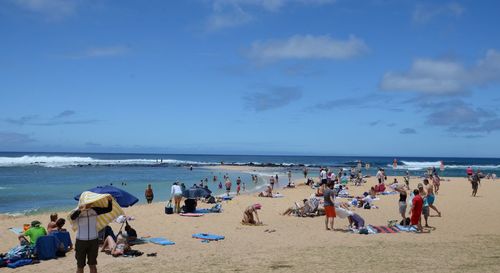 People on beach against sky
