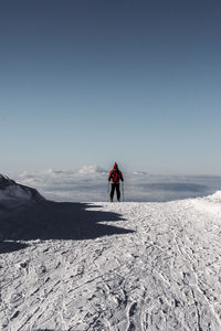 Rear view of person on snowcapped mountain against sky