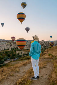 Rear view of man with hot air balloons
