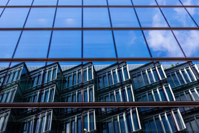 Low angle view of glass building against sky