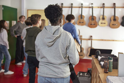 Teenagers attending guitar lesson