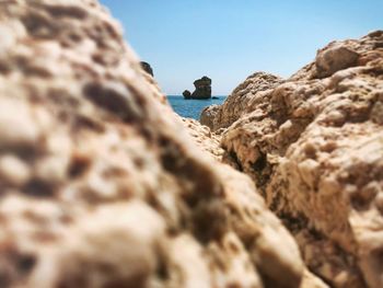 Rock formation on beach against clear sky