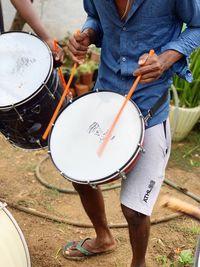 Low section of man playing drum