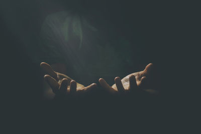 Close-up of hands against black background