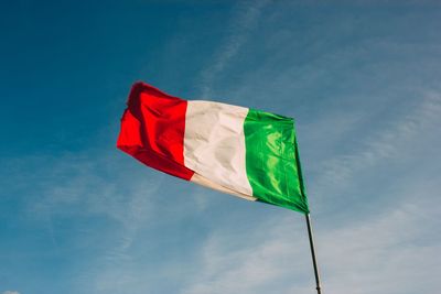 Low angle view of flag against blue sky