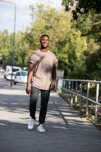 Portrait of smiling young man standing on road