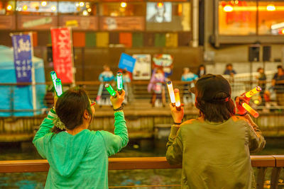 Rear view of people holding food at temple