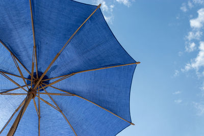 Low angle view of umbrella against blue sky