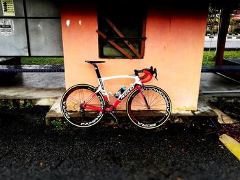 Bicycle parked against brick wall