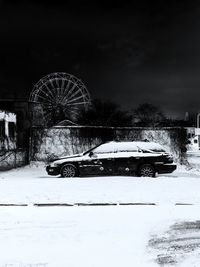 Ferris wheel on snow covered field against sky
