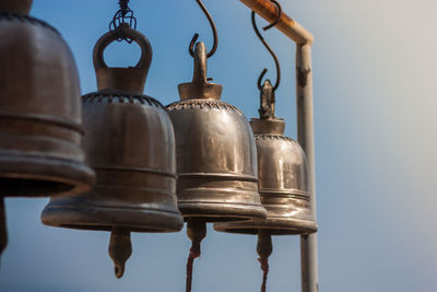 Low angle view of bell hanging against clear sky