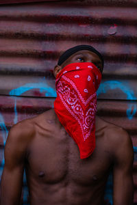 Rear view of shirtless man standing against wall