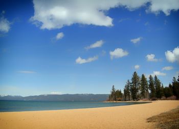 Scenic view of beach against cloudy sky