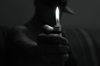 Close-up of hand holding lit cigarette lighter