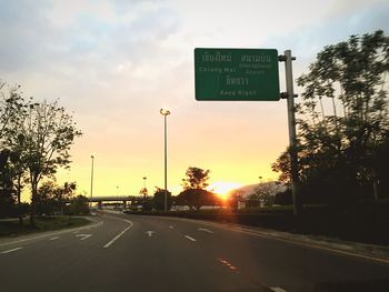 Road sign against sky during sunset