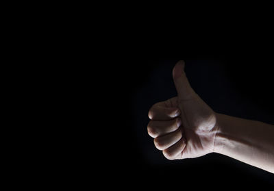 Close-up of human hand over black background