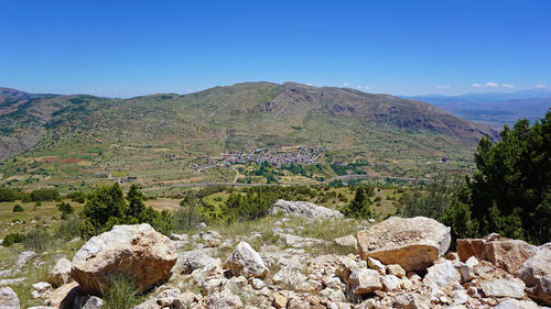 Scenic view of rocky mountains against blue sky