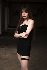 Portrait of young woman standing in darkroom