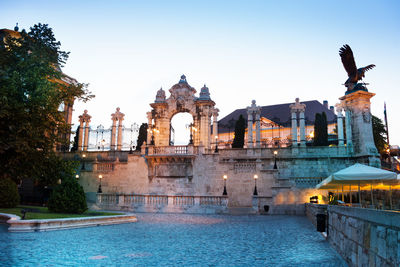 View of statue of illuminated buildings against clear sky