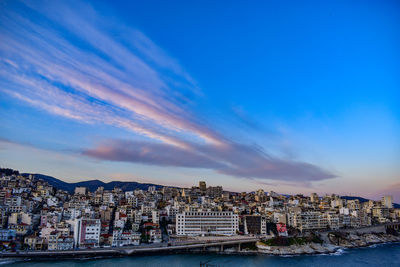 Buildings in city against cloudy sky