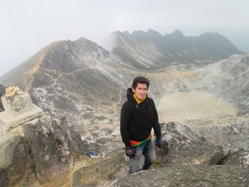 Portrait of man standing against mountain against sky.vulcano mount