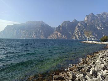 Scenic view of sea and mountains against clear blue sky