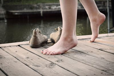 Low section of barefoot woman on wooden jetty