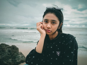 Portrait of beautiful young woman standing on beach