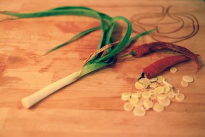 High angle view of red chili pepper and leek on wooden table