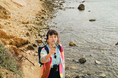 Portrait of woman holding branches at beach