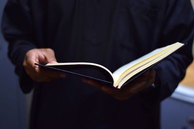 Midsection of man hand book