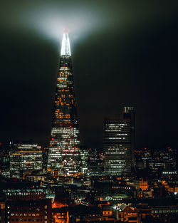 Illuminated skyscrapers against sky at night