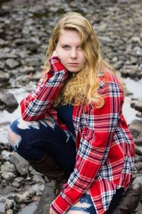 Portrait of young woman standing on footpath