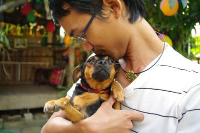 Low section of woman holding puppy
