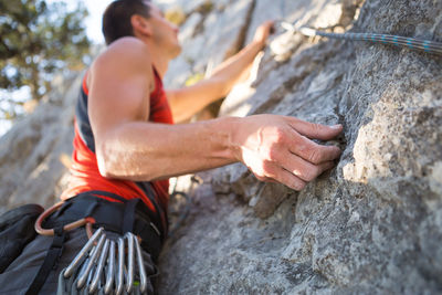 Midsection of man with rope on rock
